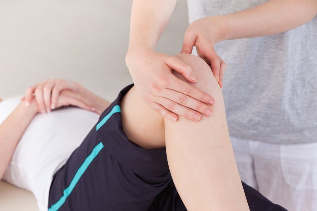 Knee being manipulated during acupuncture appointment